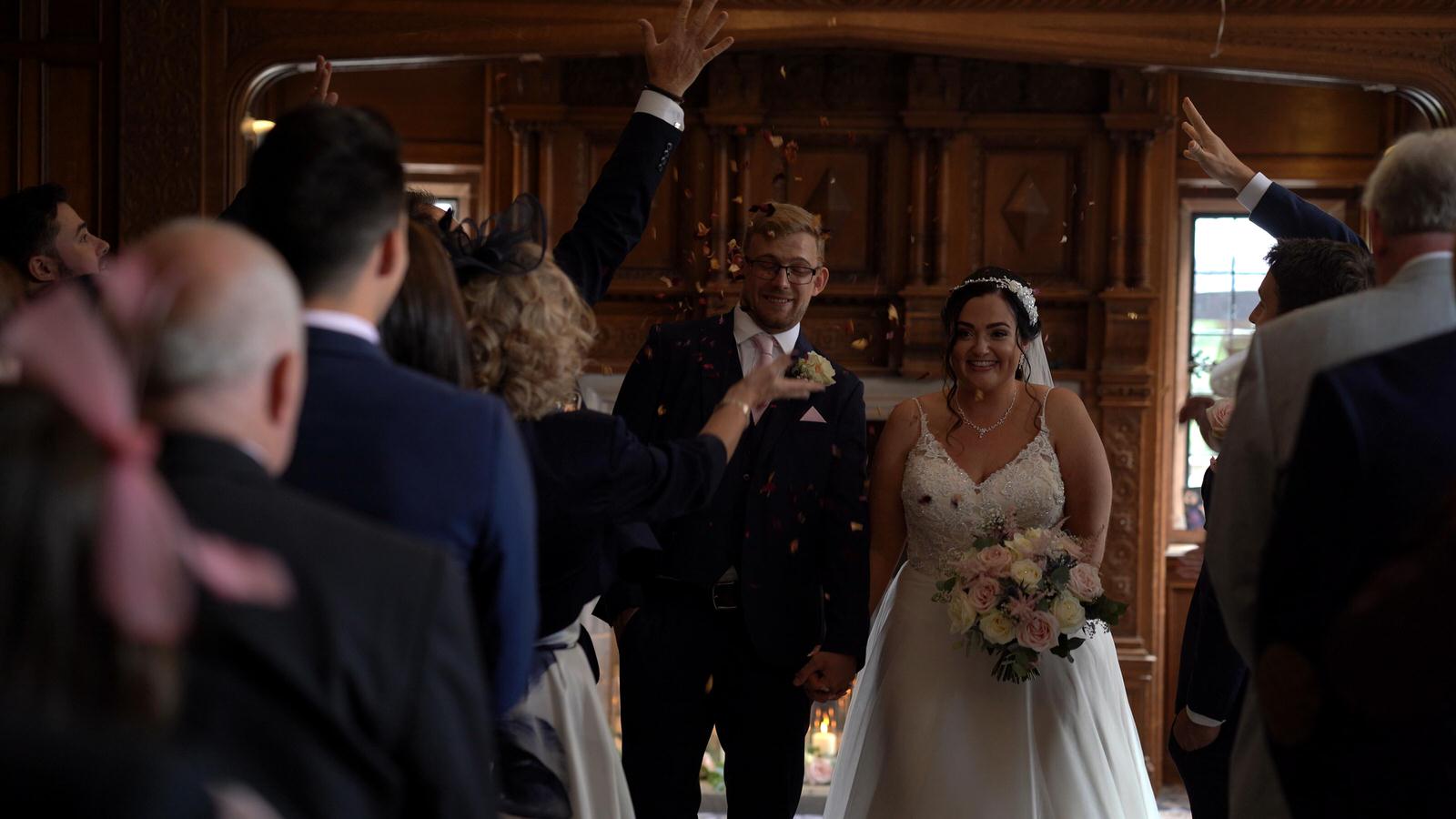 videographer films indoor aisle confetti at Inglewood Manor