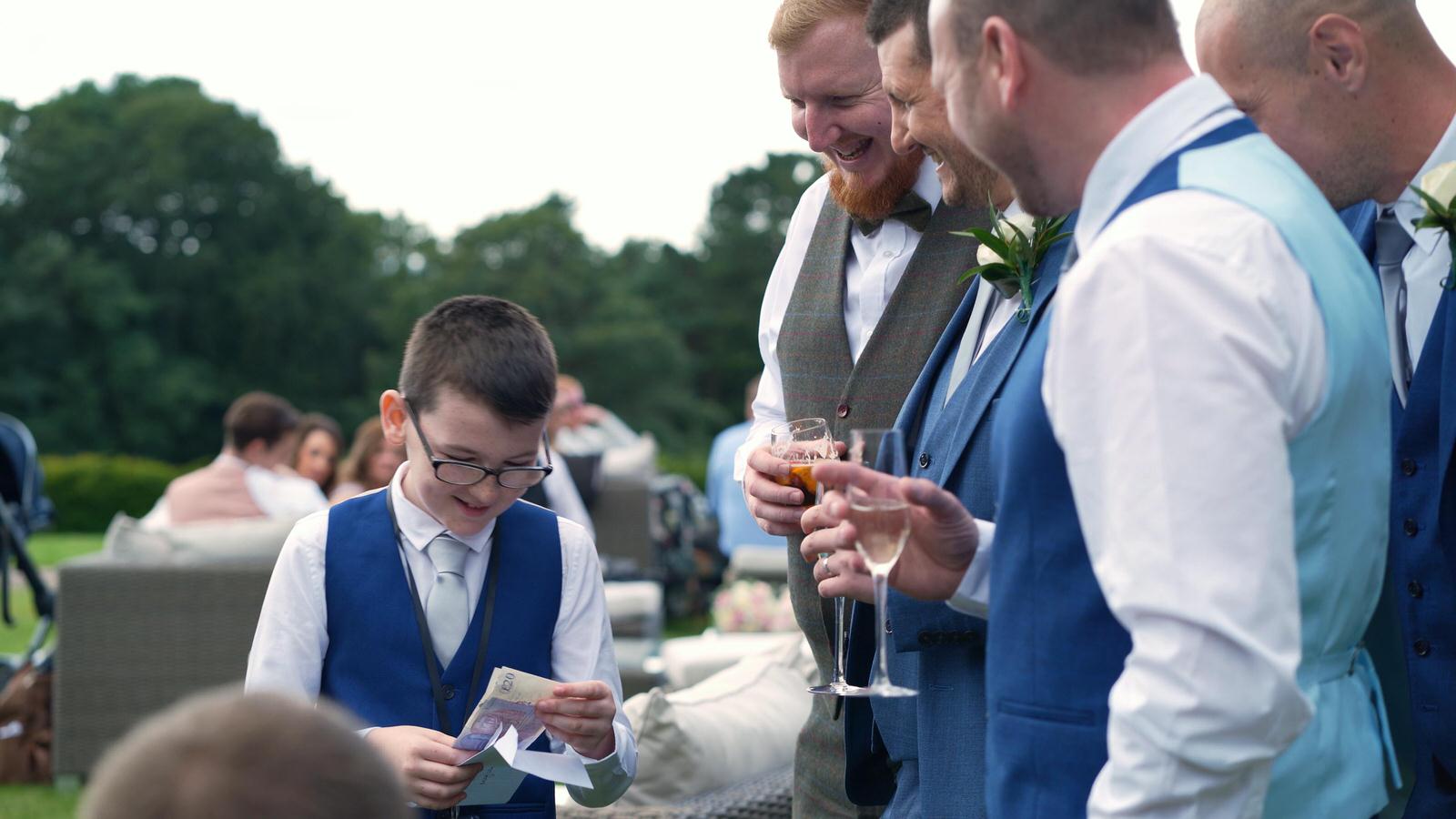 grooms son smiles at being given wedding money