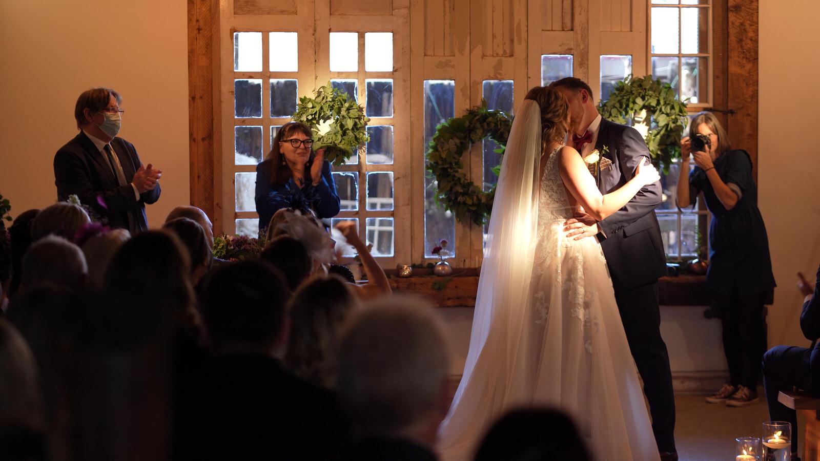 couple kiss during wedding ceremony at Owen House