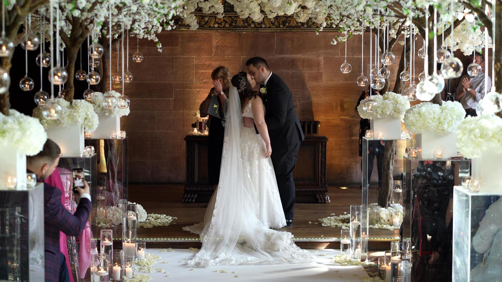 couple kiss during peckforton castle wedding ceremony