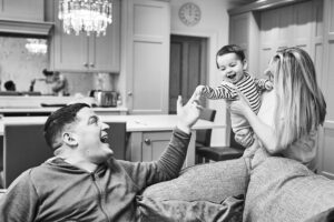 family laugh with baby in kitchen