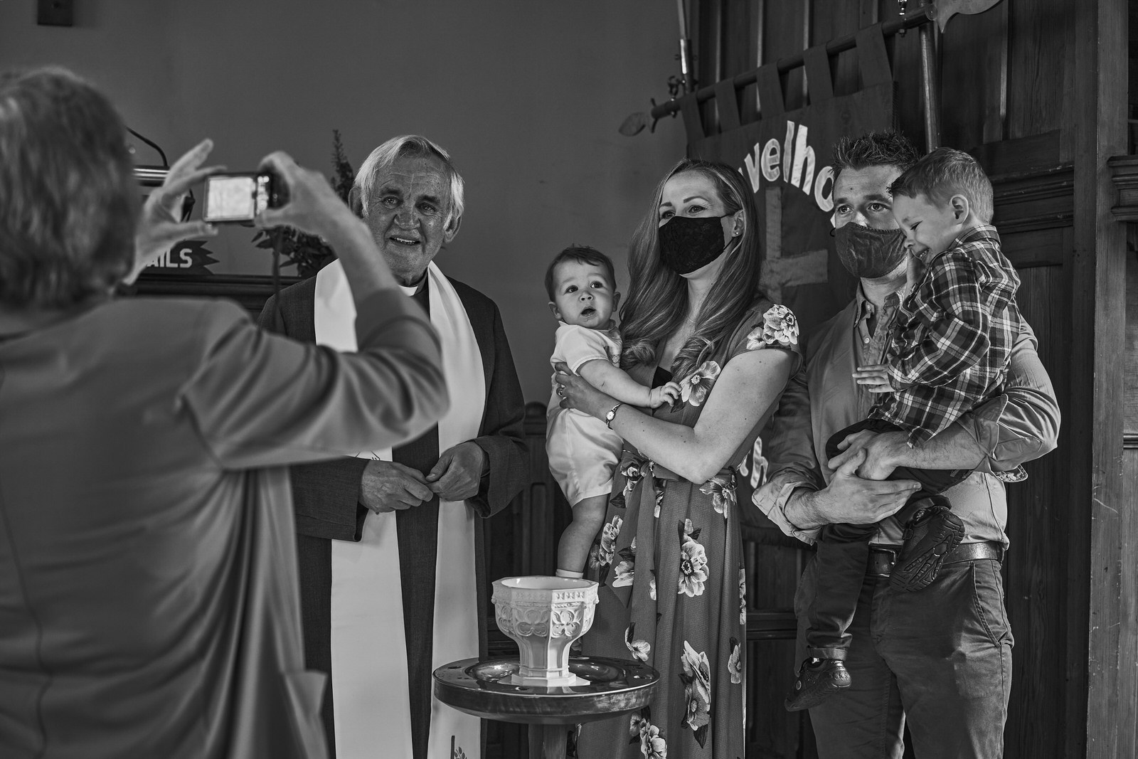 baby christening family pose for photos with guests