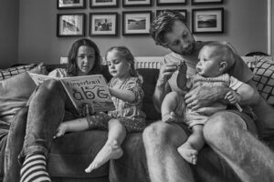 family sit together to read during family session