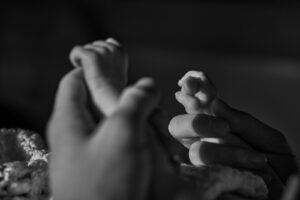 close up of newborn baby hands holding dads finger