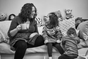 mum laughs with child whist drinking tea
