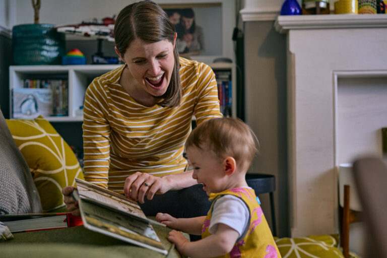 mum pulls faces as they read a book at home