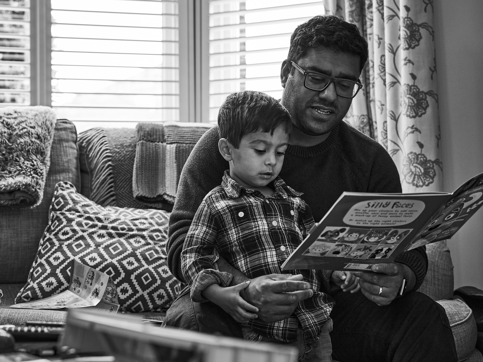 dad sits and reads with son during photoshoot