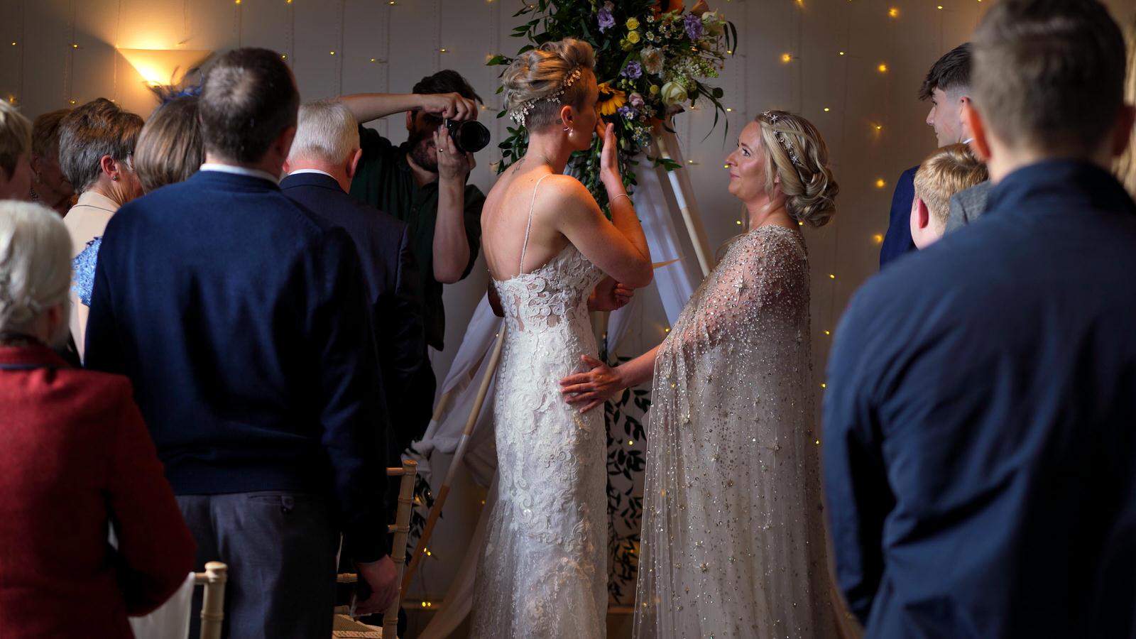 brides wipe back tears on video during vows
