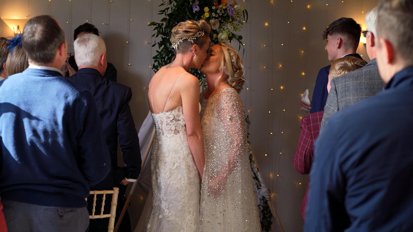 two brides kiss during their celebrant led wedding at Chilli Barn Otley