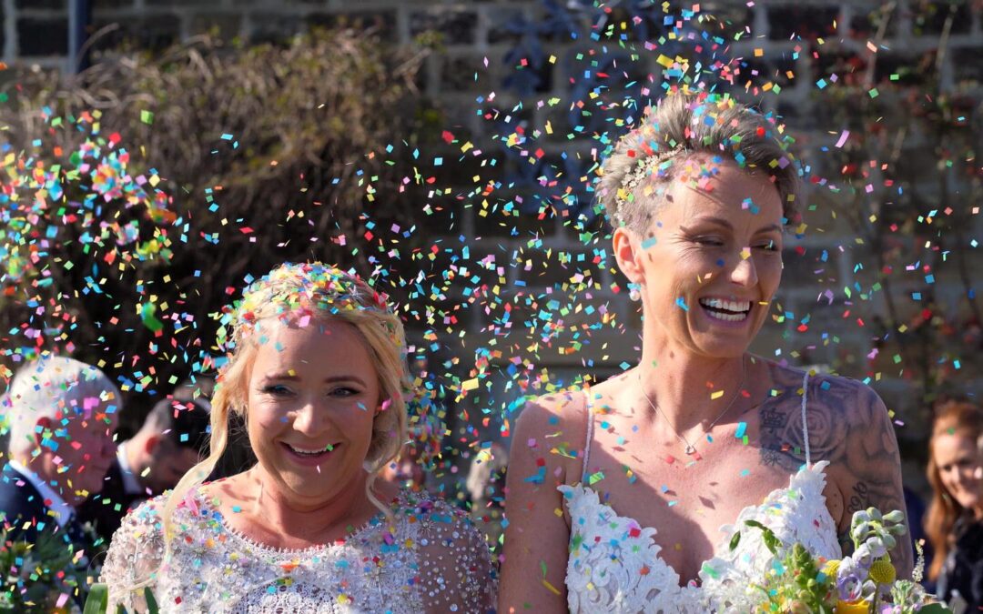 close up video still of brides and rainbow confetti