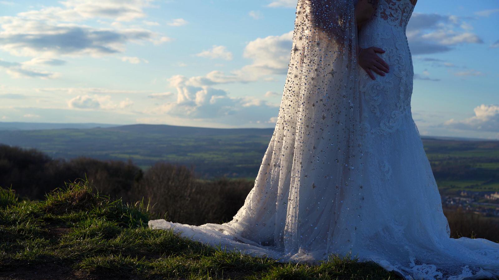 a close up shot of two brides wedding dresses in the sun