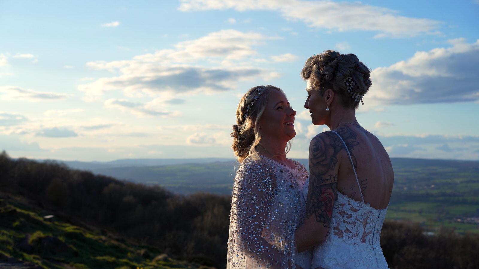 a couple cuddle up for wedding videographer in Otley Forest Park