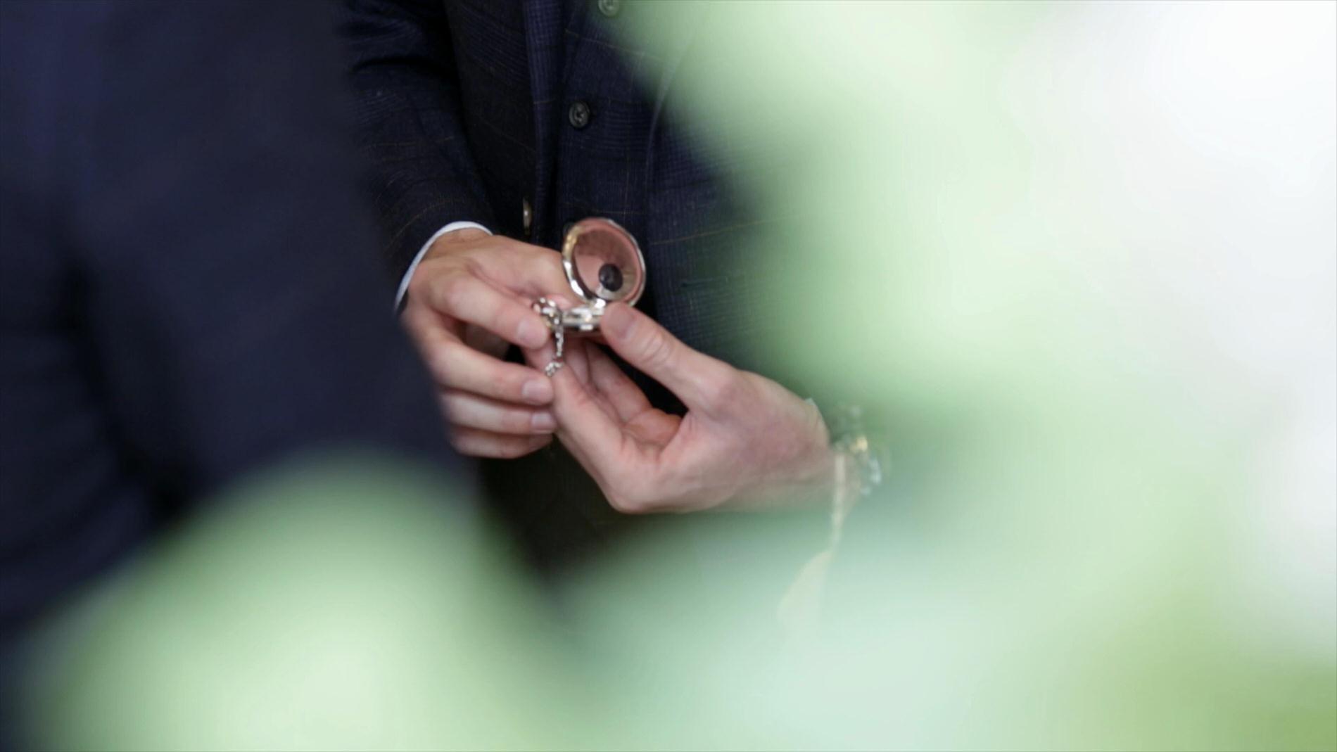 video still of Groom sneaking a look at pocket watch