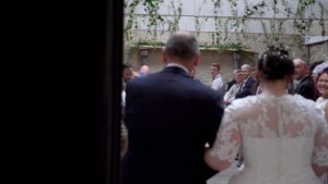 bride walks down the aisle during barn wedding at Wyresdale Park