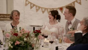 couple laugh at dads speech in white barn