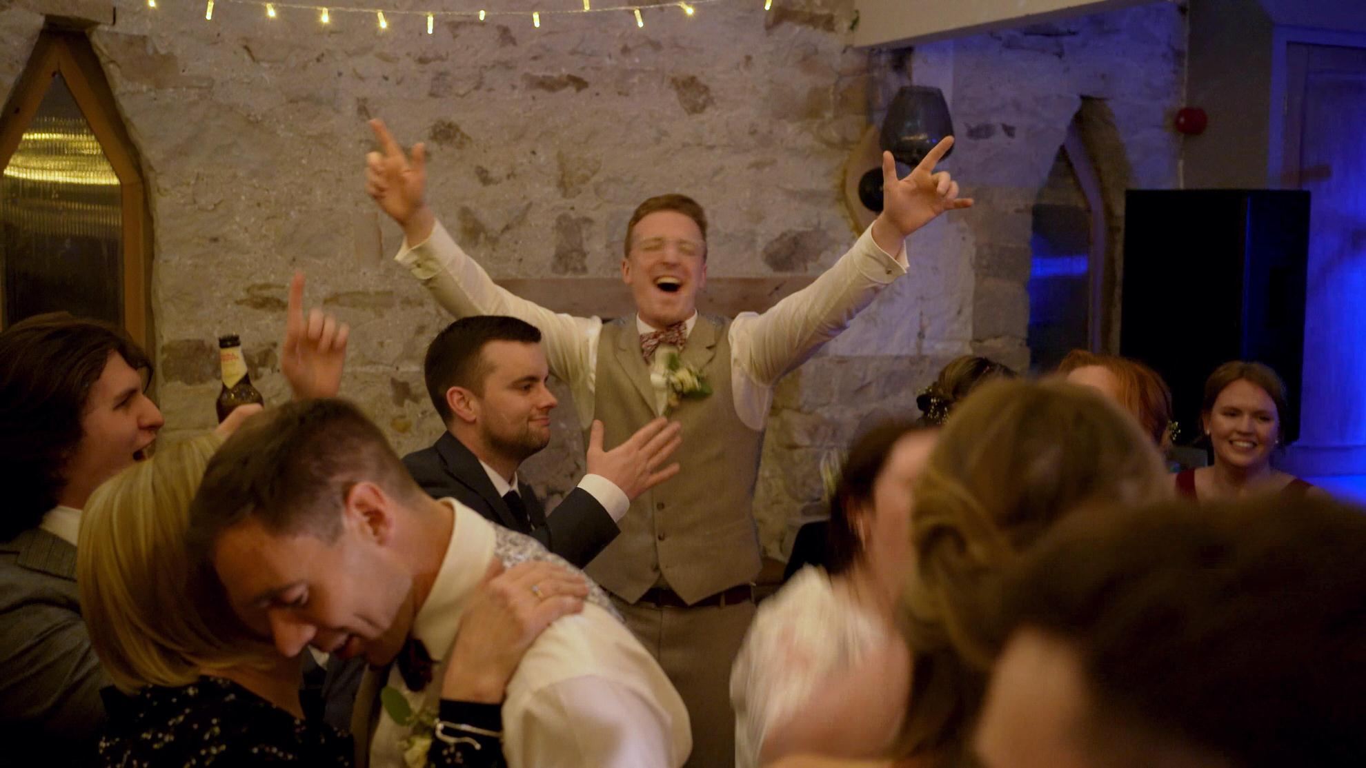 groom dances enthusiastically at wedding