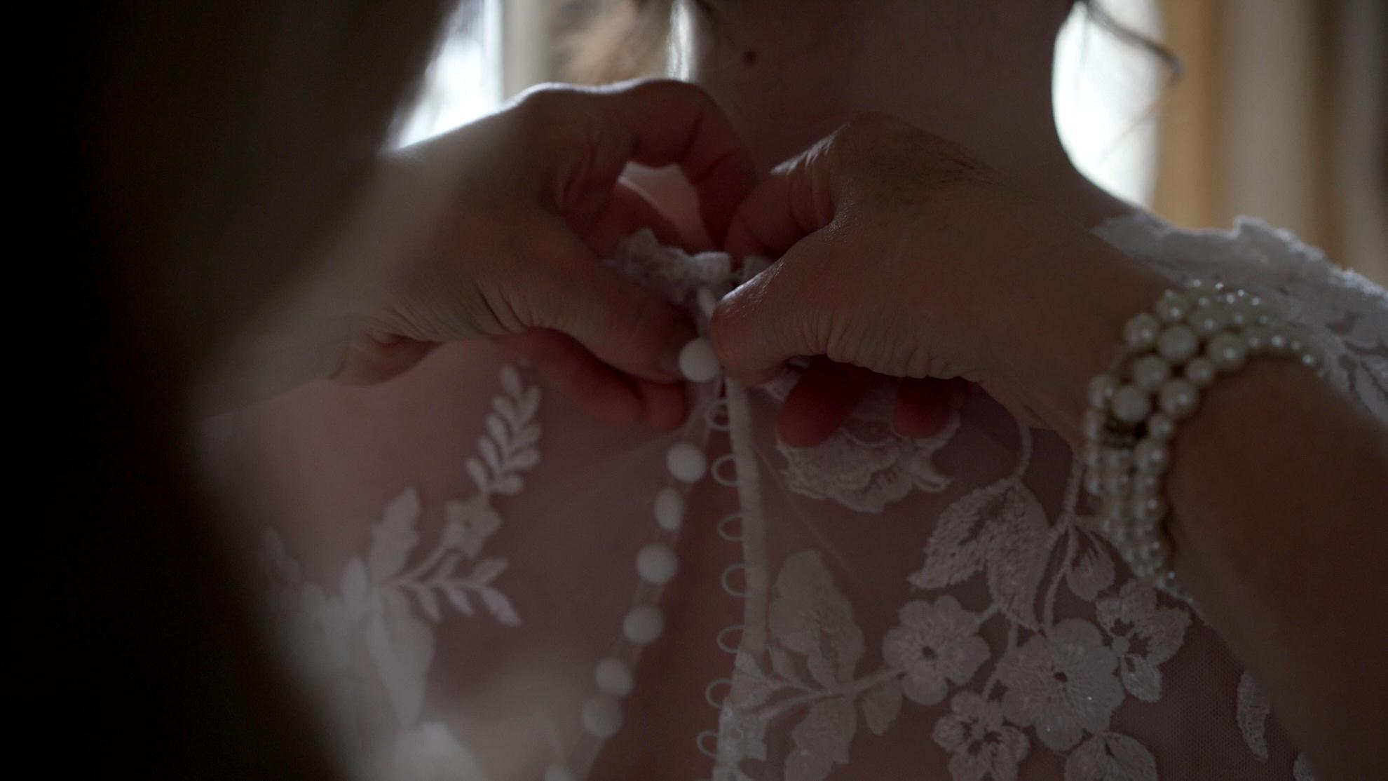 close up video of buttons on a wedding dress