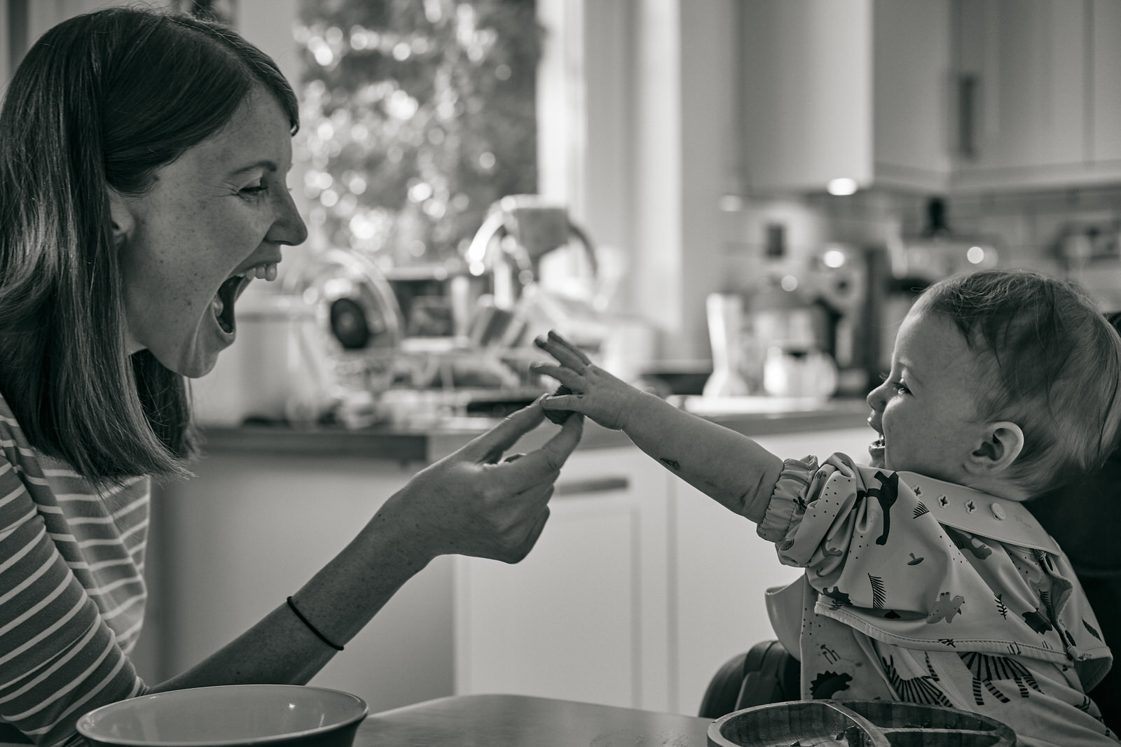 baby reaches for raspberry during breakfast