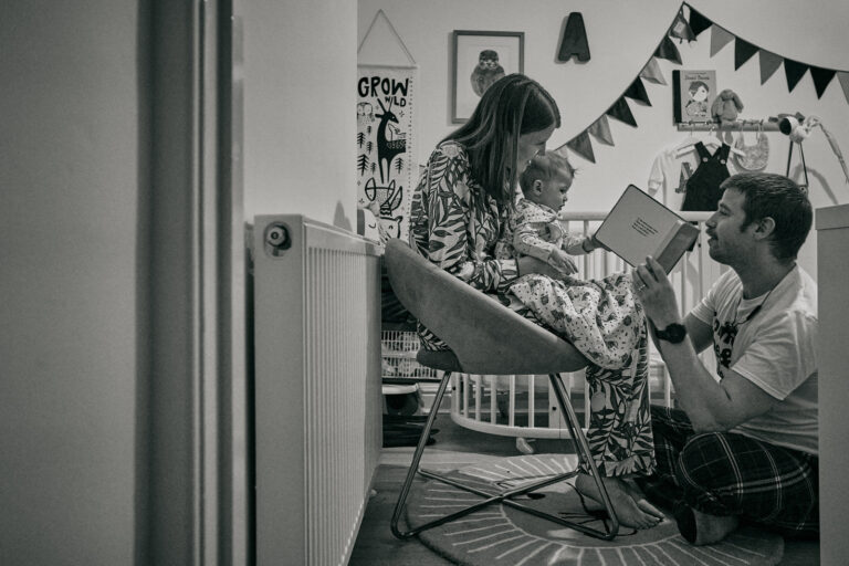 family enjoy a relaxed story time before bed at home in Manchester