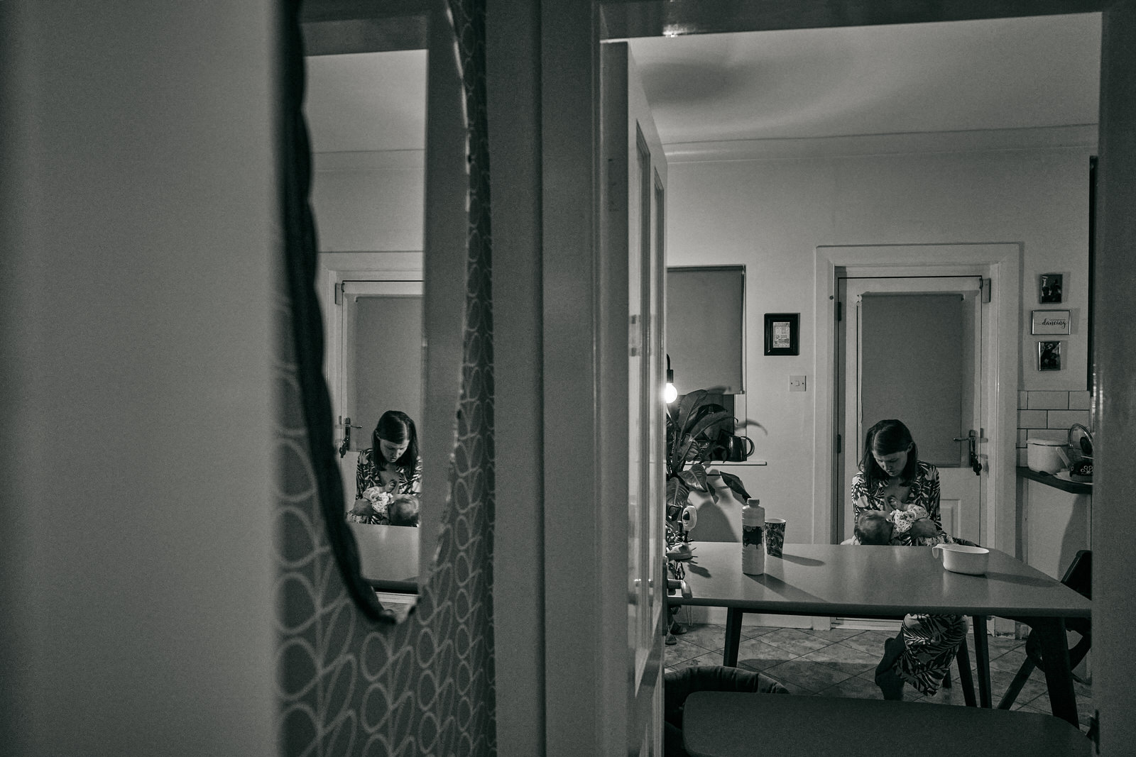 mum feeds a sleepy baby in the kitchen
