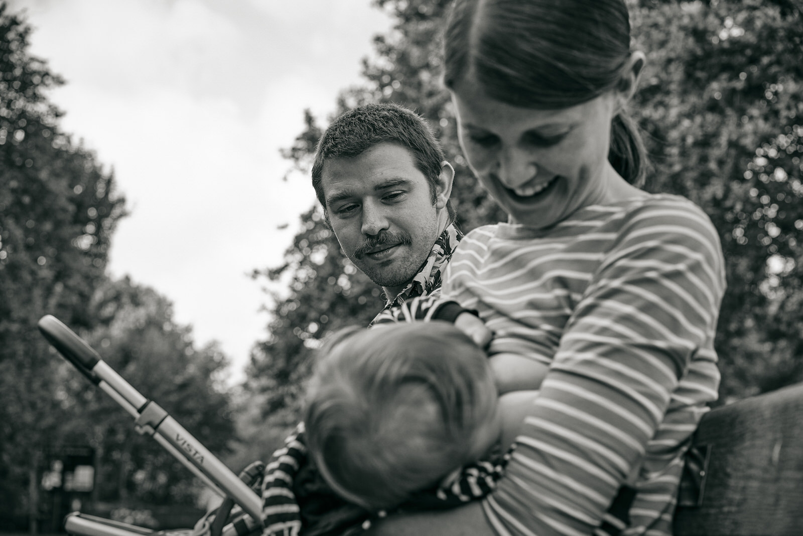 candid moment as dad looks at mum breastfeeding