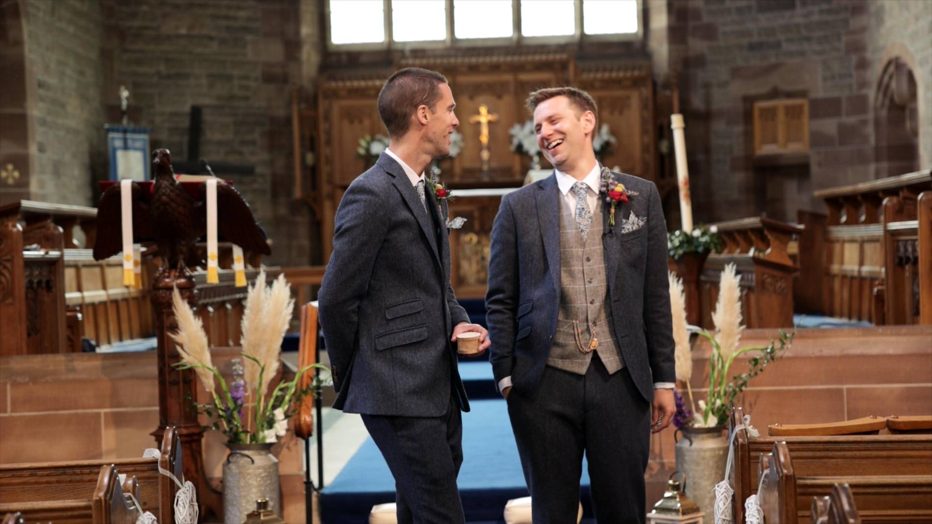 groom laughs with best man in church