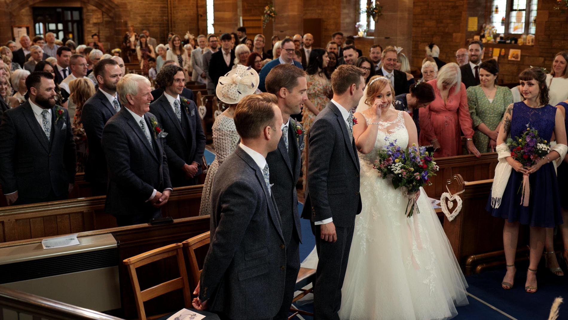 bride wipes tear during ceremony at St Lukes Orrell
