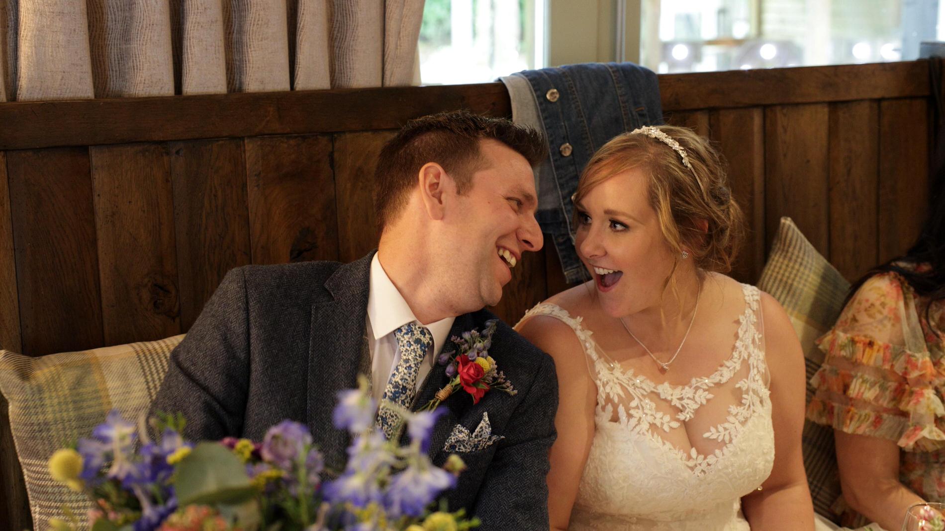 bride and groom laugh at each other during speech