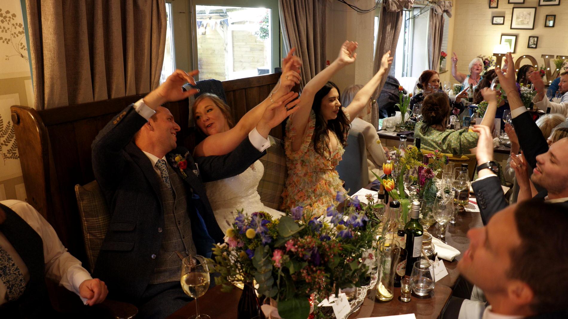 guests wave their arms along with the singing waiters