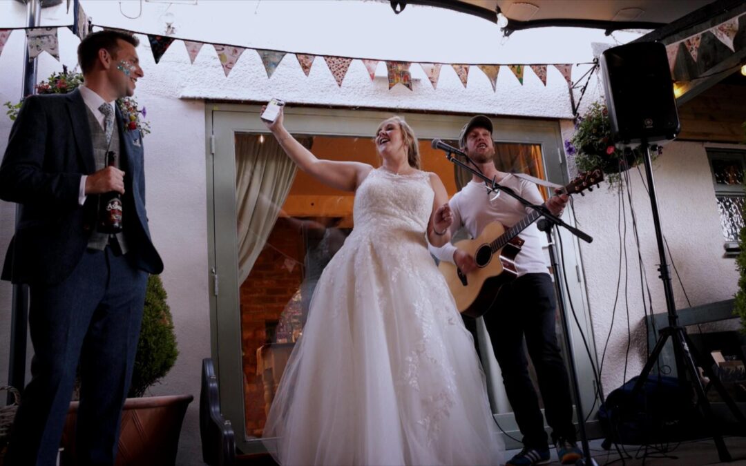 Bride sings along with acoustic singer during wedding at Roby Mill