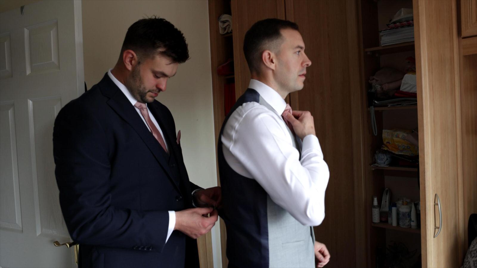 groom gets help getting ready