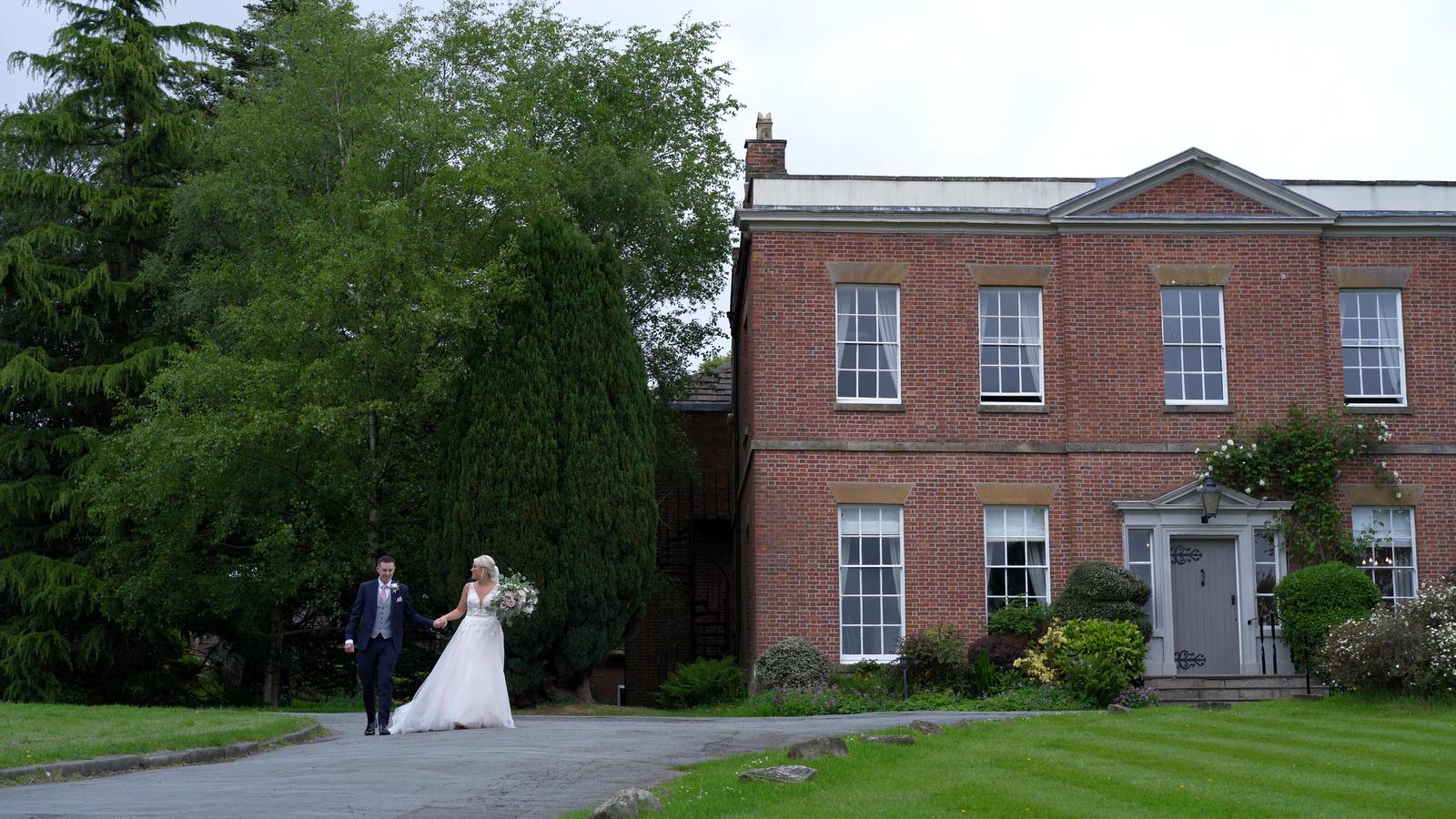 bride and groom walk outside Rivington Manor House