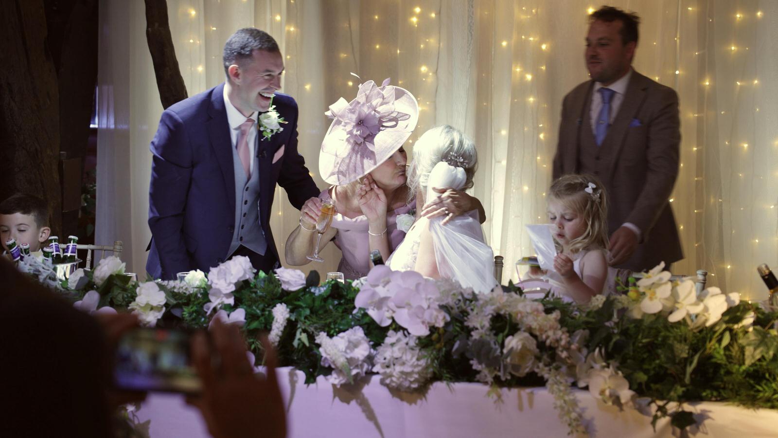 mother of the bride gives the bride a hug