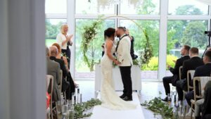 couple kiss during lakeside wing wedding at Capesthorne Hall
