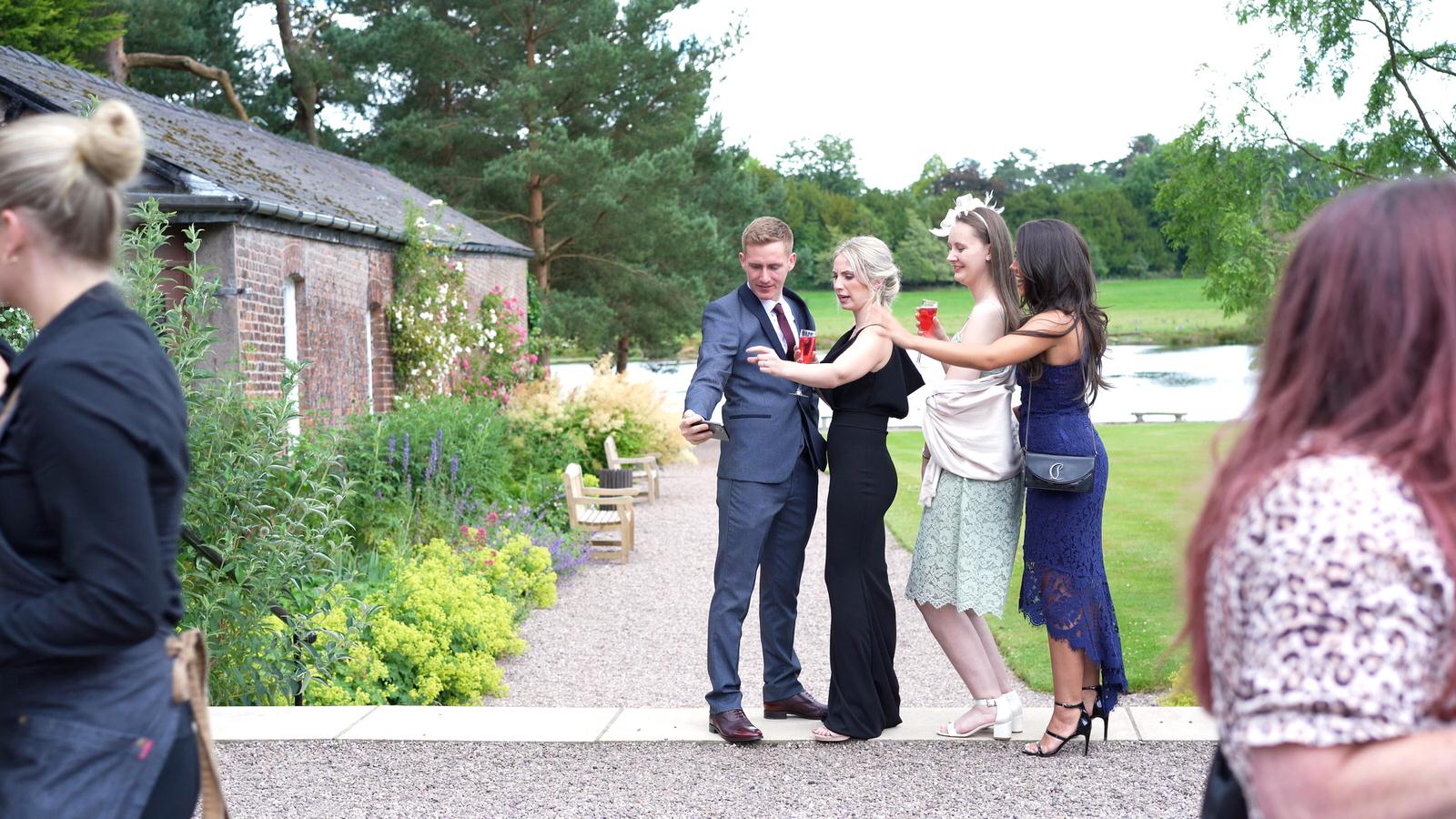 guests pose for a selfie on Capesthorne Hall lawn