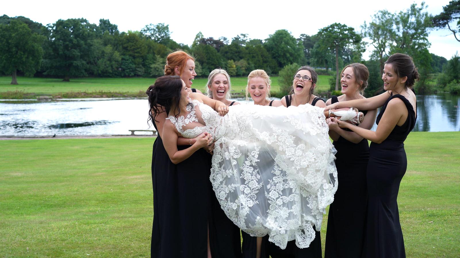 bridesmaids lift the bride for a fun photo