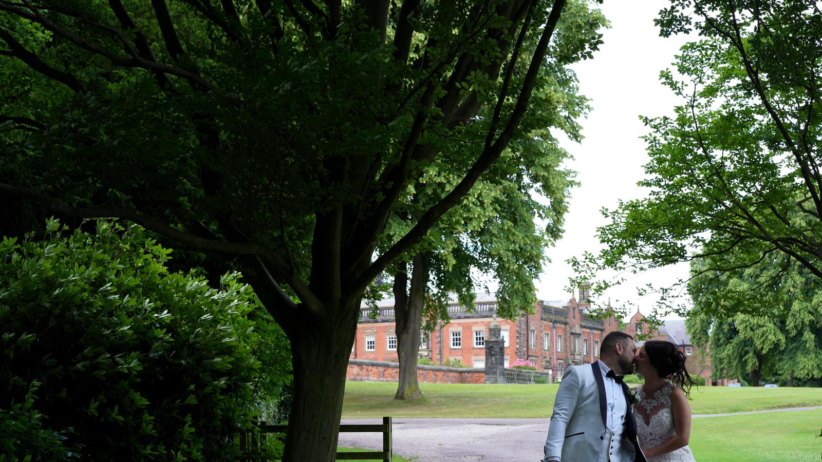 couple kiss outside capesthorne hall for videographer