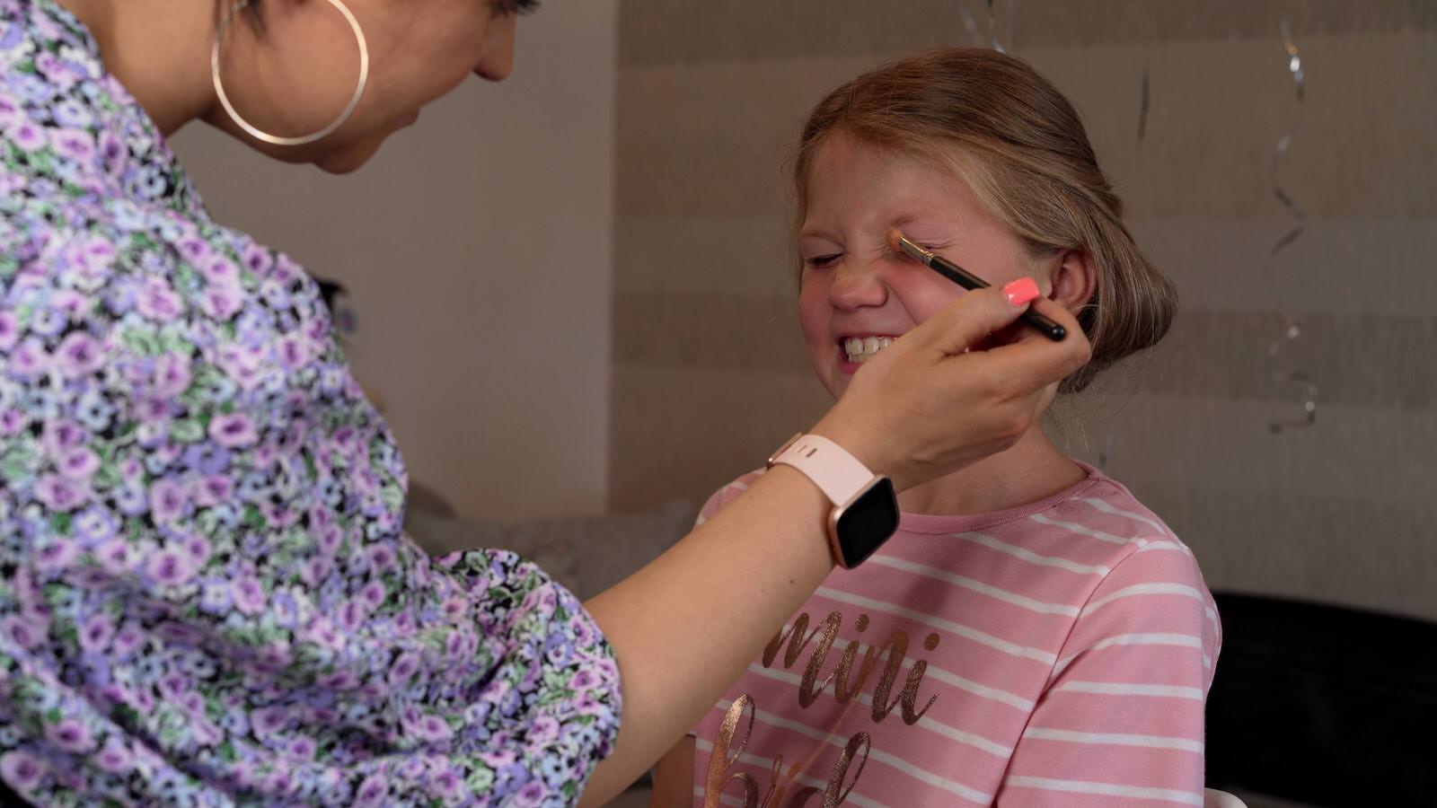 flowergirl gets glitter eyeshadow put on