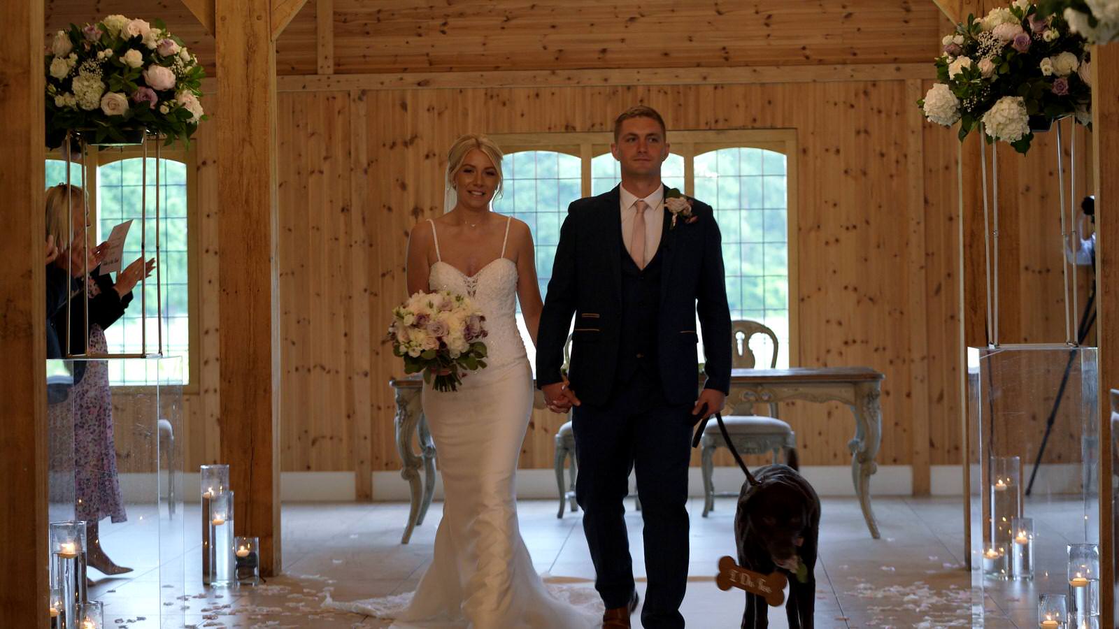 couple and their dog walk back down the aisle