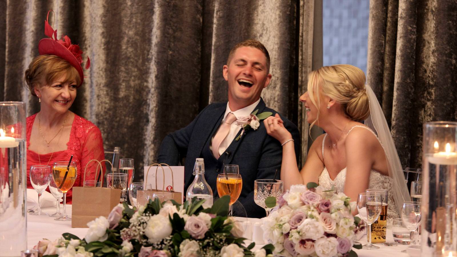 couple laugh during wedding speeches
