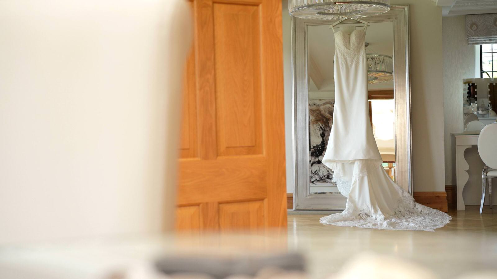 lace wedding dress hangs in Merrydale Manor dressing room