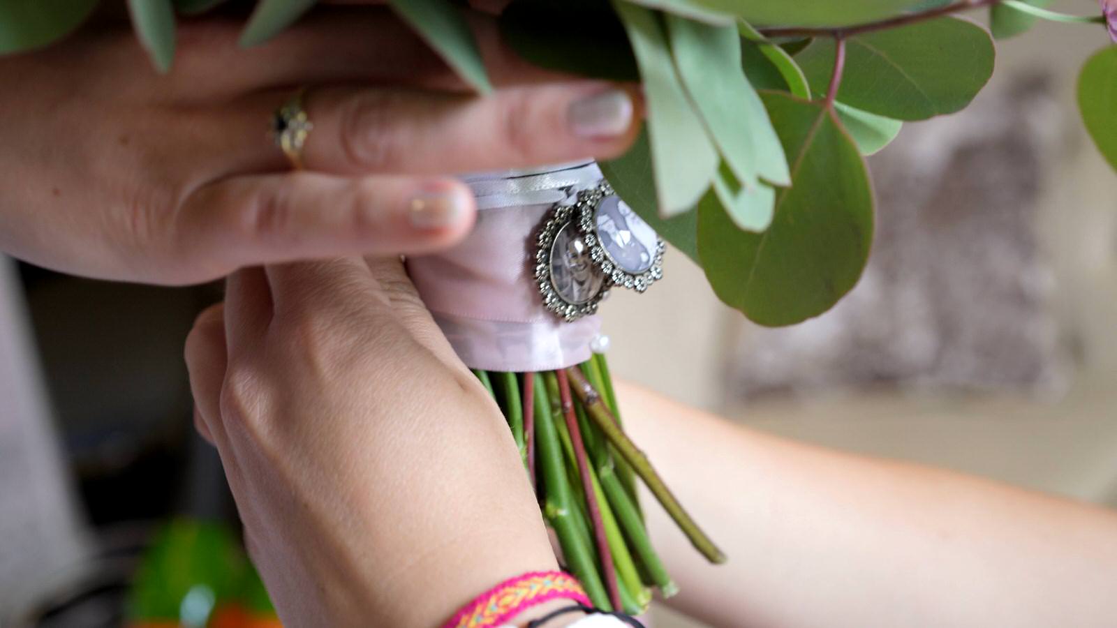 close up of family lockets on bridal bouquet