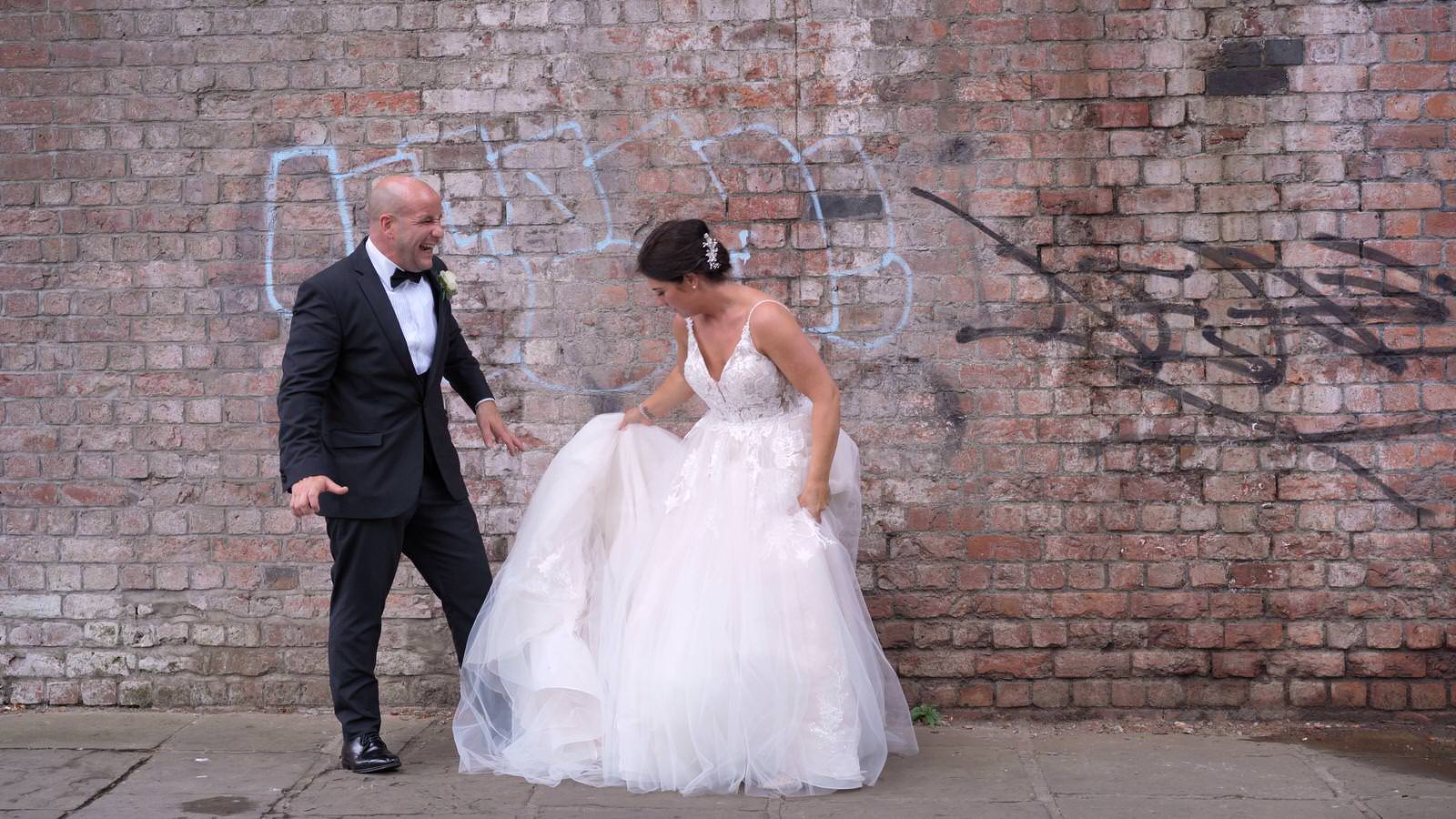 candid video moment as groom laughs at brides big dress