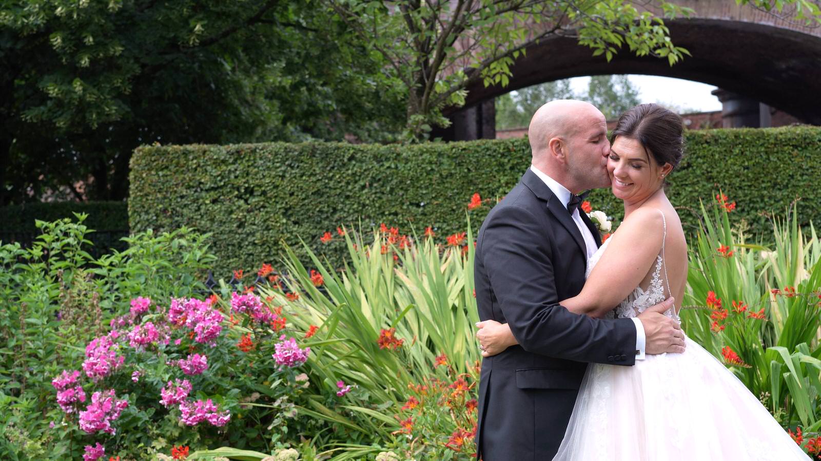 bride and groom kiss in gardens of Lock keepers cottage Manchester