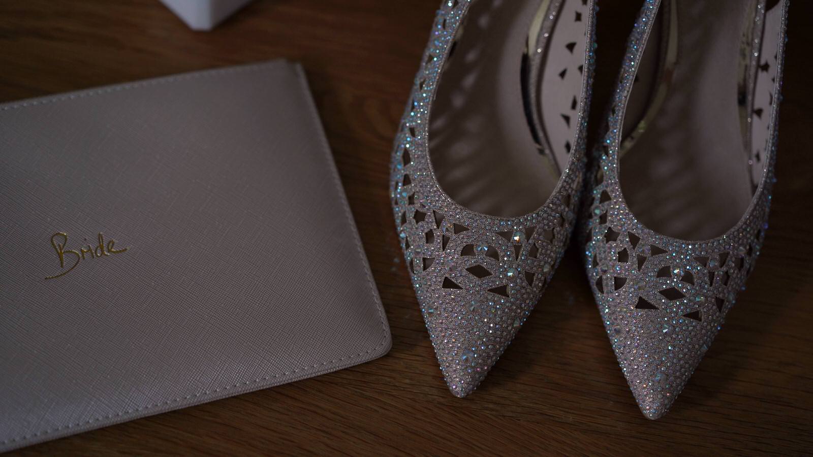 sparkly wedding shoes sit next to bride bag