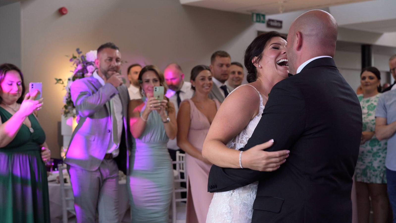bride laughs with groom during first dance