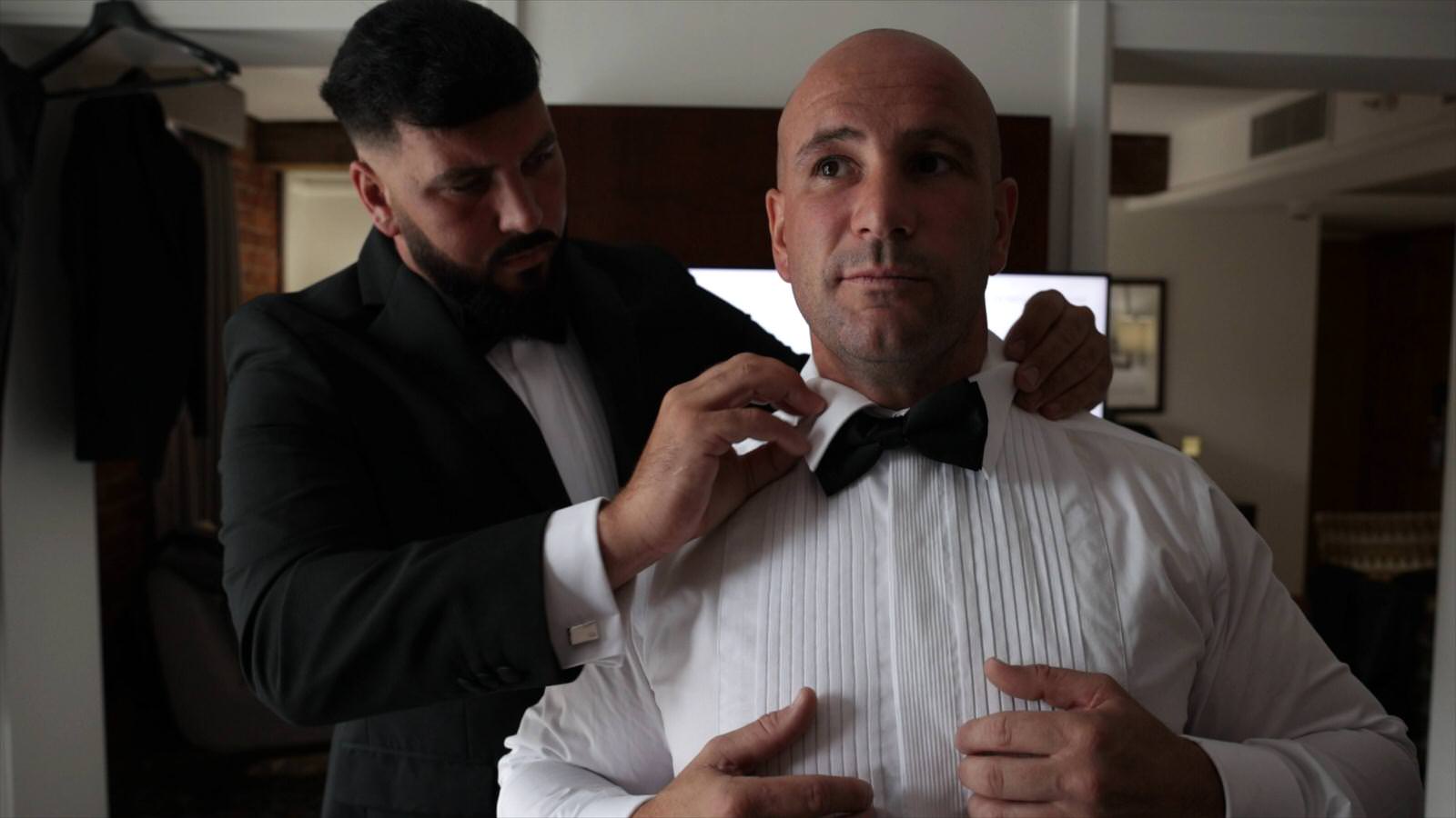 groom gets help with bowtie in manchester hotel