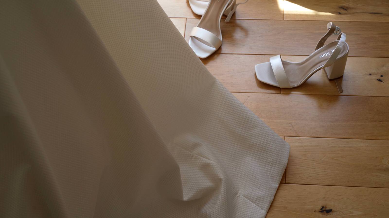 brides shoes on the floor as she gets dressed