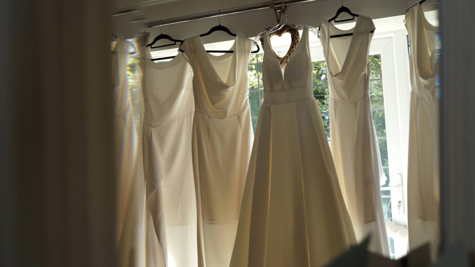 video still of wedding dress and white bridesmaid dresses hanging
