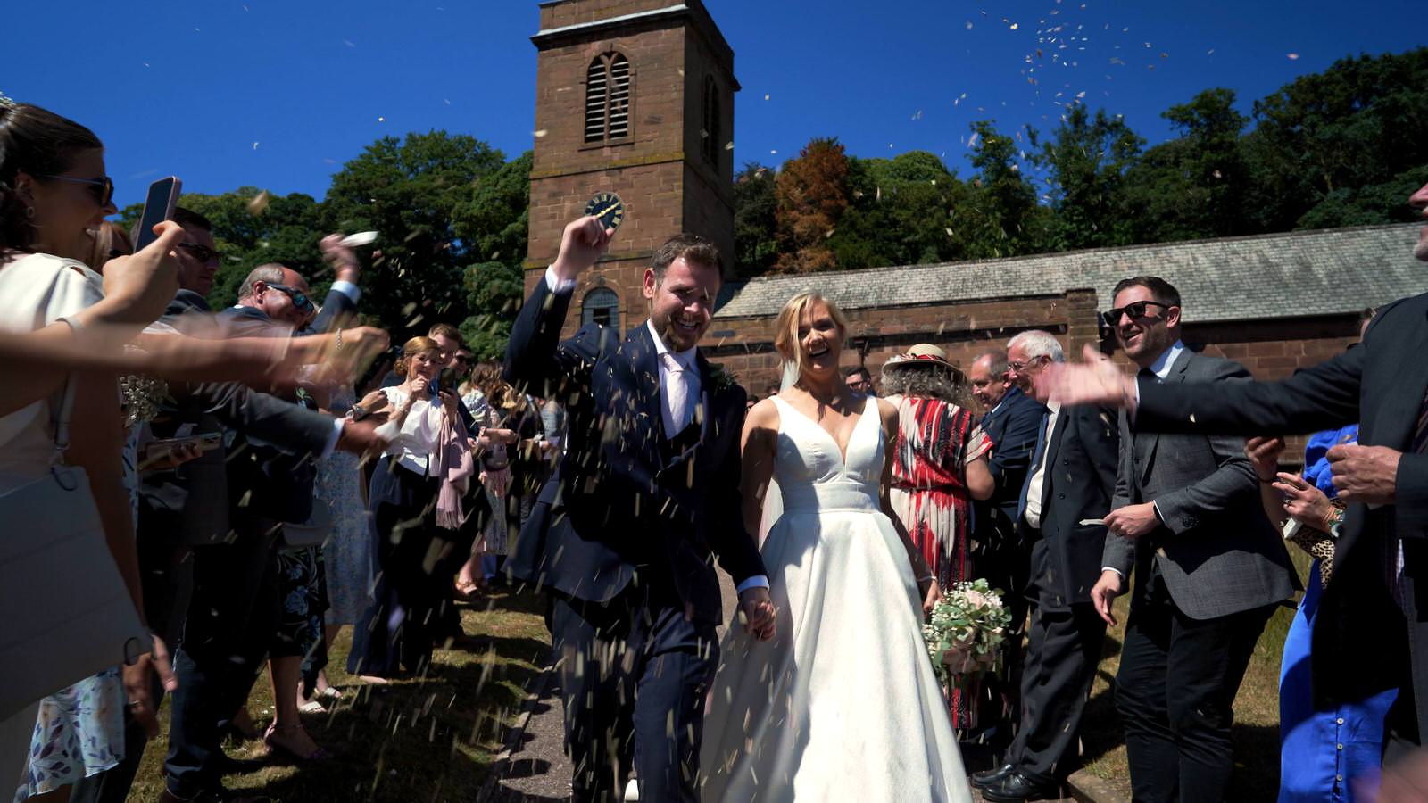 couple showered in confetti outside Burton village church